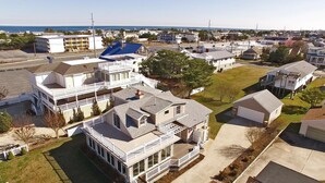 Un quartier résidentiel composé de plusieurs maisons à deux étages, dotées de vérandas et offrant une vue dégagée sur l’océan.
