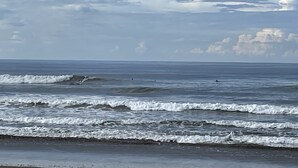 A beach with waves and a cloudy sky.
