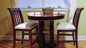 A dining table with two chairs, a basket with items, and a window with blinds. - A historical hideaway (Cleveland)