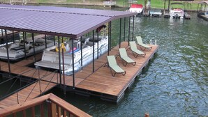 A dock with a covered seating area and lounge chairs. - Centrally Located Lake House with a Secluded Feel Boat Slip Included (HOT SPRINGS NATIONAL PARK)