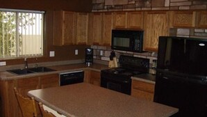 A kitchen with wooden cabinets, a microwave, a stove, and a refrigerator. - Single Level! 3B 2B Johnson Ranch. (San Tan Valley)