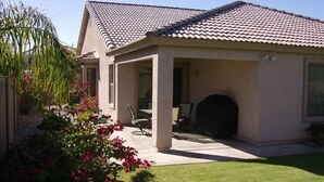 A house with a covered patio, a fireplace, and a well-maintained lawn. - Single Level! 3B 2B Johnson Ranch. (San Tan Valley)