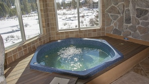 A hot tub with a view of a snowy landscape through large windows. - Spacious Luxury Condo Private Hot Tub and Sanua in Unit 1000' to ski lift (Keystone)