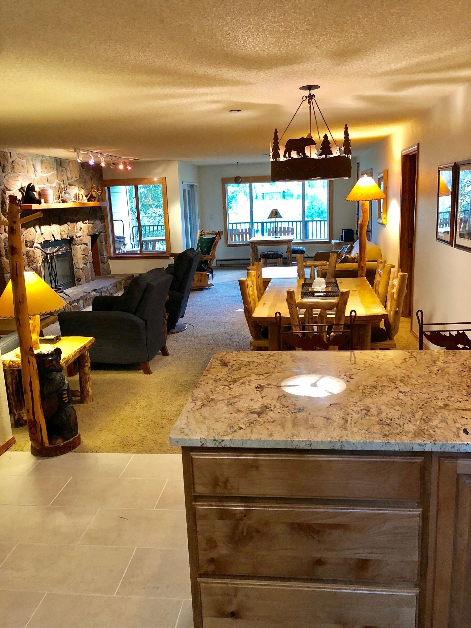 A cozy living room with a fireplace, a dining area with a wooden table and chairs, and a kitchen with a granite countertop.