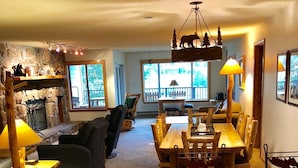 A cozy living room with a fireplace, a dining area with a wooden table and chairs, and a kitchen with a granite countertop. - Spacious Luxury Condo Private Hot Tub and Sanua in Unit 1000' to ski lift (Keystone)