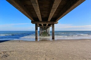 A pier extending into the ocean with a clear view of the water and sky.