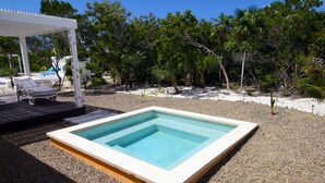 A rectangular pool with a white border, surrounded by pebbles. There is a covered area with a white canopy and two lounge chairs. - Empyrean - Tangerine - Paradise in Whitby, North Caicos (Whitby)