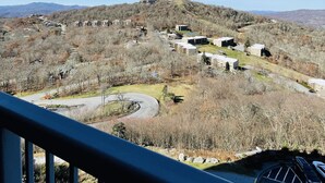 Ein Wohngebiet mit Häusern auf einer Hügelschaft, einer kurvenreichen Straße und einem strahlend blauen Himmel.