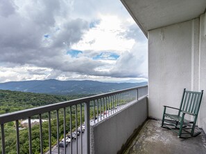 A balcony with a view of a parking lot and mountains. - 2B Condo w/ Panoramic Slope-Side Views (Sugar Mountain)