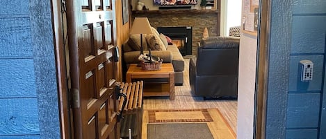 Una sala de estar con chimenea, televisor y sofá.
