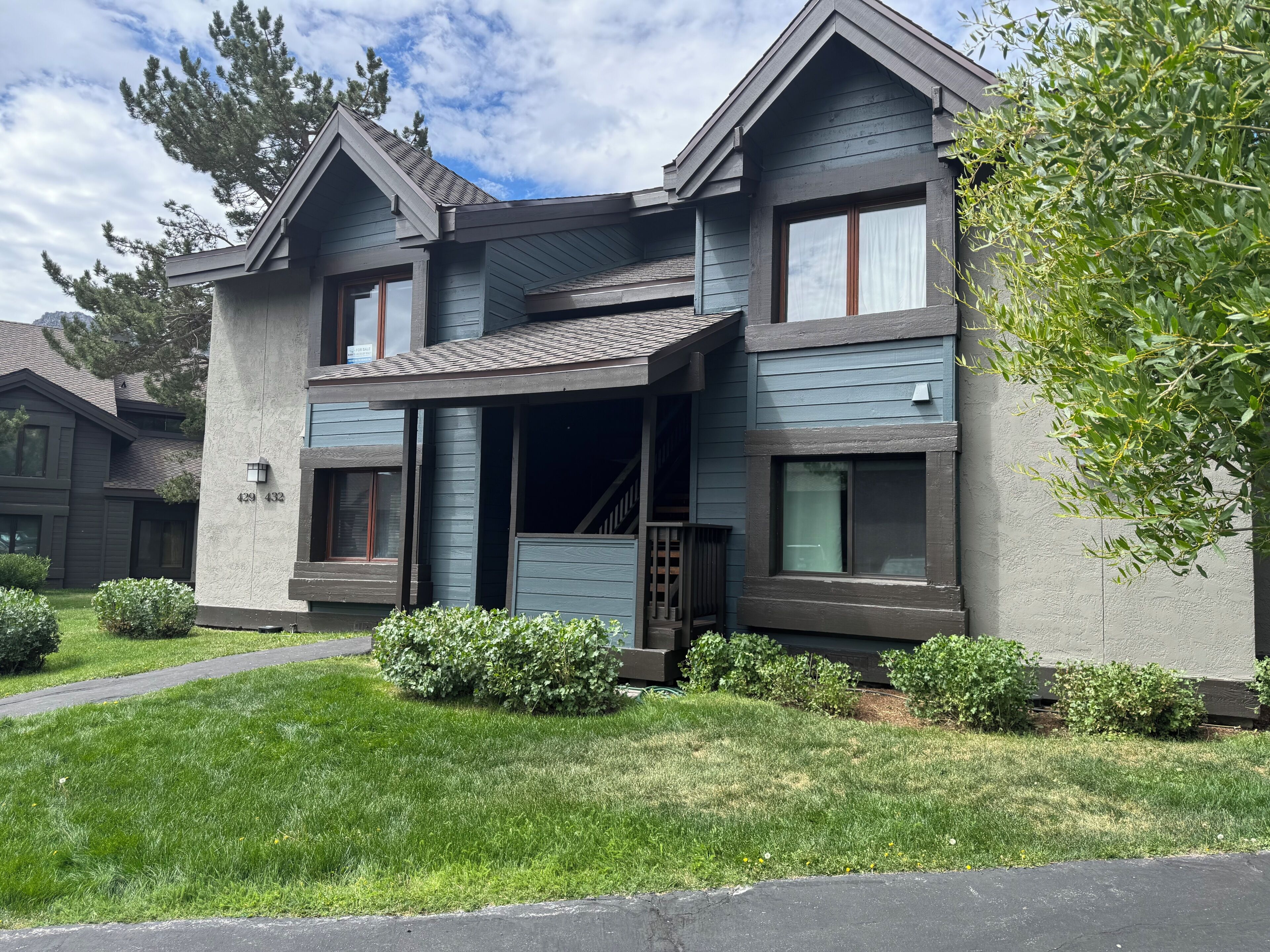 A two-story house with a front porch, a visible staircase, and a mailbox.
