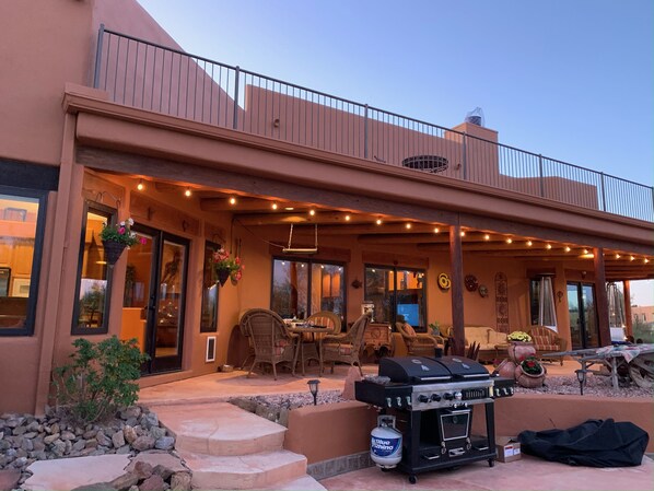 A covered patio with outdoor furniture, a grill, and string lights. - Private Desert Oasis with heated pool; spa; covered deck; spectacular views. (Scottsdale)