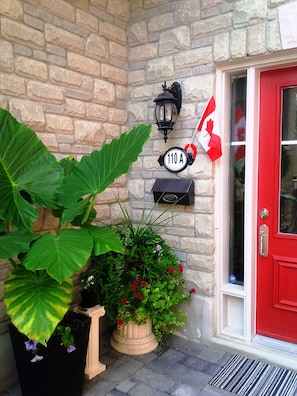 A red door with a mailbox and a street sign.