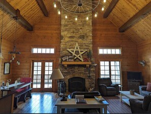 Cozy retreat with a stone fireplace, leather sofa, and television.