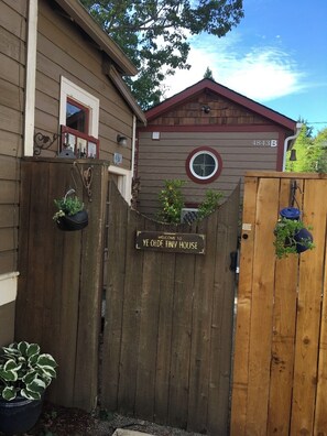 Enter a charming abode with a classic design, featuring a wooden gate and a circular window.