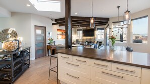 A modern kitchen with a large island, pendant lighting, and a view of the city. - Luxury beach vacation - Ocean view bright and fun (Manhattan Beach)