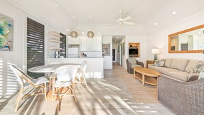 Un amplio espacio de sala con un sofá, una mesa de comedor con sillas y una cocina al fondo.