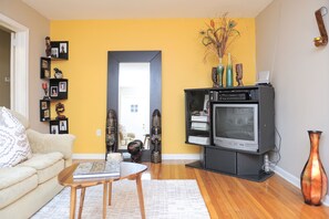 Relax in the living room with a comfortable sofa, coffee table, and mounted TV.