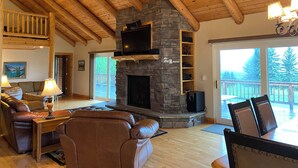 A cozy living room with a stone fireplace, leather furniture, and a wooden ceiling. - Lodge on the Golf Course in Star Valley Ranch, WY.  Best View and location!! (Star Valley Ranch)