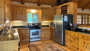 A kitchen with wooden cabinets, a stainless steel refrigerator, an oven, and a microwave. - Lodge on the Golf Course in Star Valley Ranch, WY.  Best View and location!! (Star Valley Ranch)