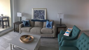 A living room with a sofa, two side tables, a coffee table, and a window with a view.