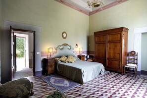 Un dormitorio con una cama, un armario de madera y una silla.