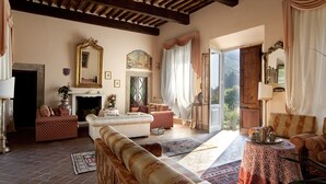 A spacious living room with a fireplace, comfortable seating, and a view of the outdoors. - Historic panoramic villa near Lucca (Lucca)