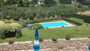 A pool surrounded by a stone wall, with a view of a green landscape and hills in the background. - Historic panoramic villa near Lucca (Lucca)