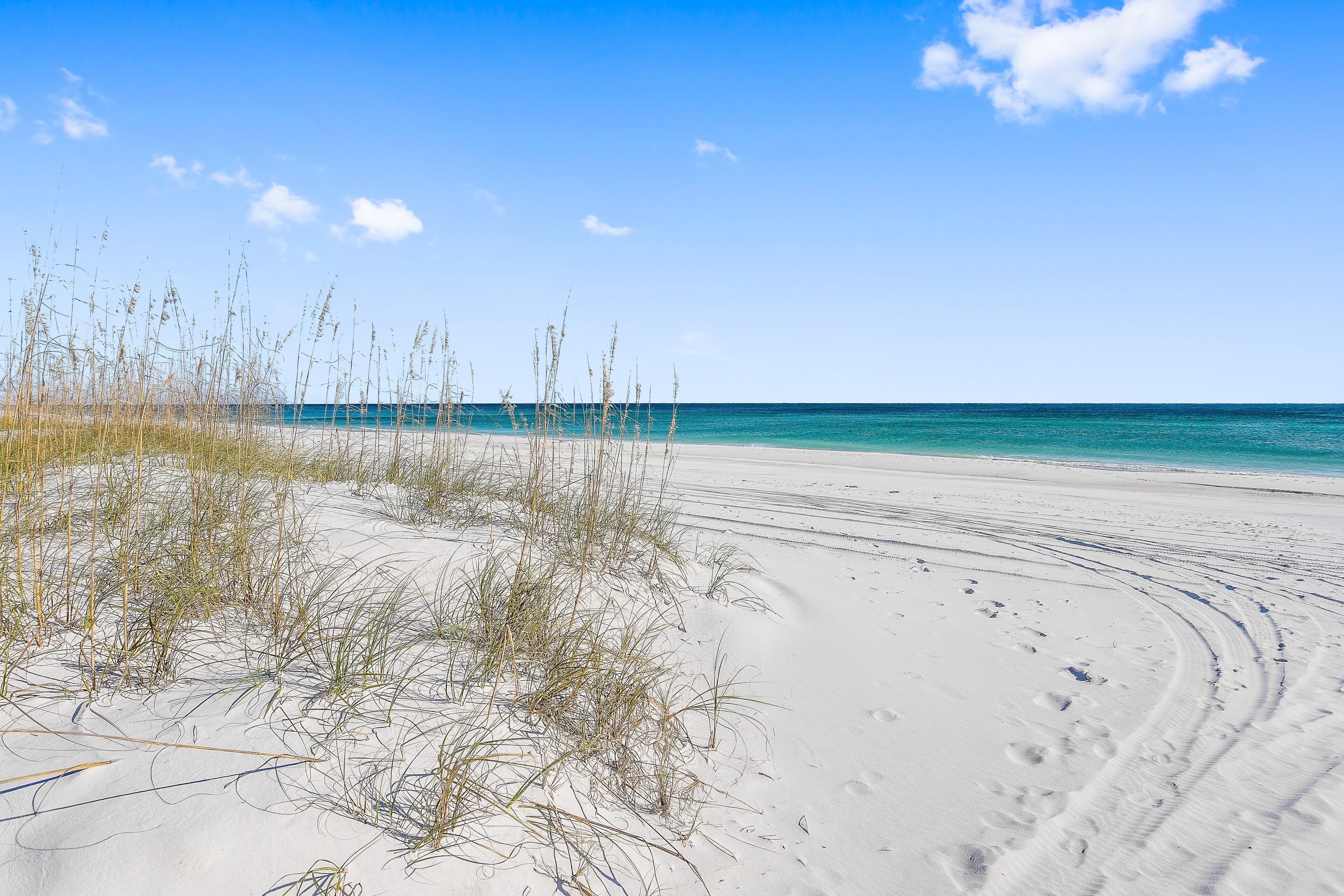 Ranta lähistöllä, aurinkotuoleja, rantapyyhkeitä