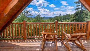 Una terraza de madera con una silla y una mesa de madera.