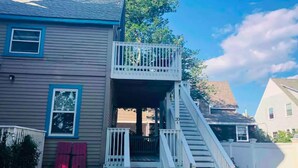 A two-story house with a balcony, a set of stairs, and a red shutter. - Delightful Beachside two-bedroom apartment (Old Orchard Beach)