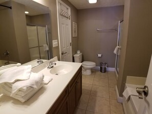 A bathroom with a sink, toilet, and shower.