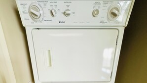 Una unidad de lavadora y secadora Kenmore de carga frontal con múltiples perillas y configuraciones.