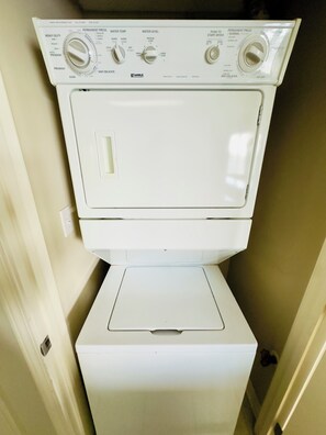A Kenmore front-loading washer and dryer unit with multiple control knobs and settings.