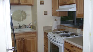 A kitchen with wooden cabinets, a stove, and a sink. - Enjoy the Sun & White Sand in Destin!!! (Destin)