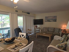 Relax in a cozy living space with a comfortable seating area, flat-screen TV, and dining table.
