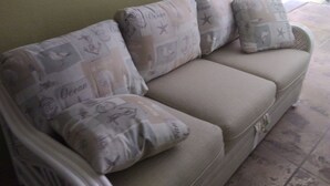 A beige sofa with ocean-themed cushions against a green wall. - Enjoy the Sun & White Sand in Destin!!! (Destin)