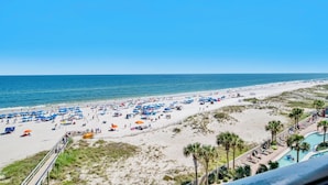 A beach with numerous umbrellas and people.