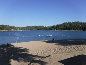 A beach with a sandy shore, calm water, and a forested background. - Yosemite Cabin Free parking WiFi Fireplace Peaceful and Quiet (Groveland)