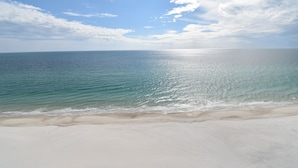 A beach with clear blue water and a sandy shore. - Enjoy this Beachfront Condo with Amazing Views! (Gulf Shores)