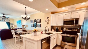 A modern kitchen with white cabinetry, stainless steel appliances, and a central island. - Enjoy this Beachfront Condo with Amazing Views! (Gulf Shores)