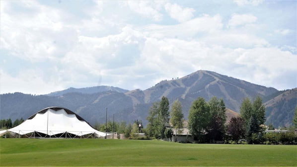 Experience the serene mountain views from this spacious tent, situated amidst lush greenery and surrounded by scenic mountains.