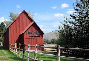 Set against a serene natural backdrop, Sundial Barn stands proudly surrounded by a fence.