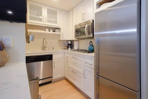Enjoy cooking in this well-equipped kitchen with a dishwasher, microwave, and refrigerator, plus a convenient island with a kettle.