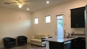 A modern kitchen with a central island, black cabinets, and a grey tiled floor. - Private One Bedroom Furnished Unit in Rancho Vistoso Eagles Summit Subdivision (Oro Valley)