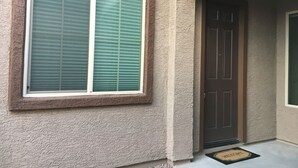 A house exterior with a large window and a door. - Private One Bedroom Furnished Unit in Rancho Vistoso Eagles Summit Subdivision (Oro Valley)