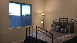 A bedroom with a single bed, a window, and a floor lamp. - Private One Bedroom Furnished Unit in Rancho Vistoso Eagles Summit Subdivision (Oro Valley)