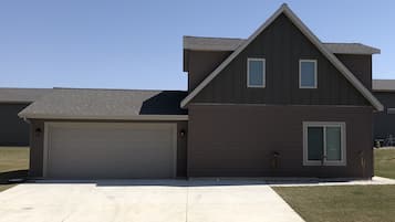Enjoy a simple, modern home with a sloped roof and a well-maintained lawn.