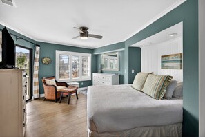 A bedroom with a bed, a desk, and a chair.