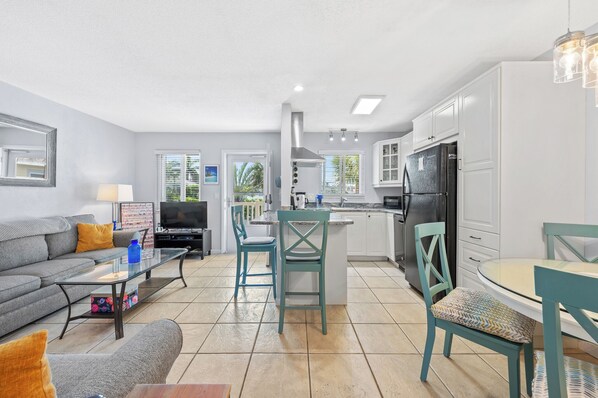A modern apartment with a living room, kitchen, and dining area. - 5 star newly renovated condo 3 min. walk to the beach, bars, food & transport (St Pete Beach)